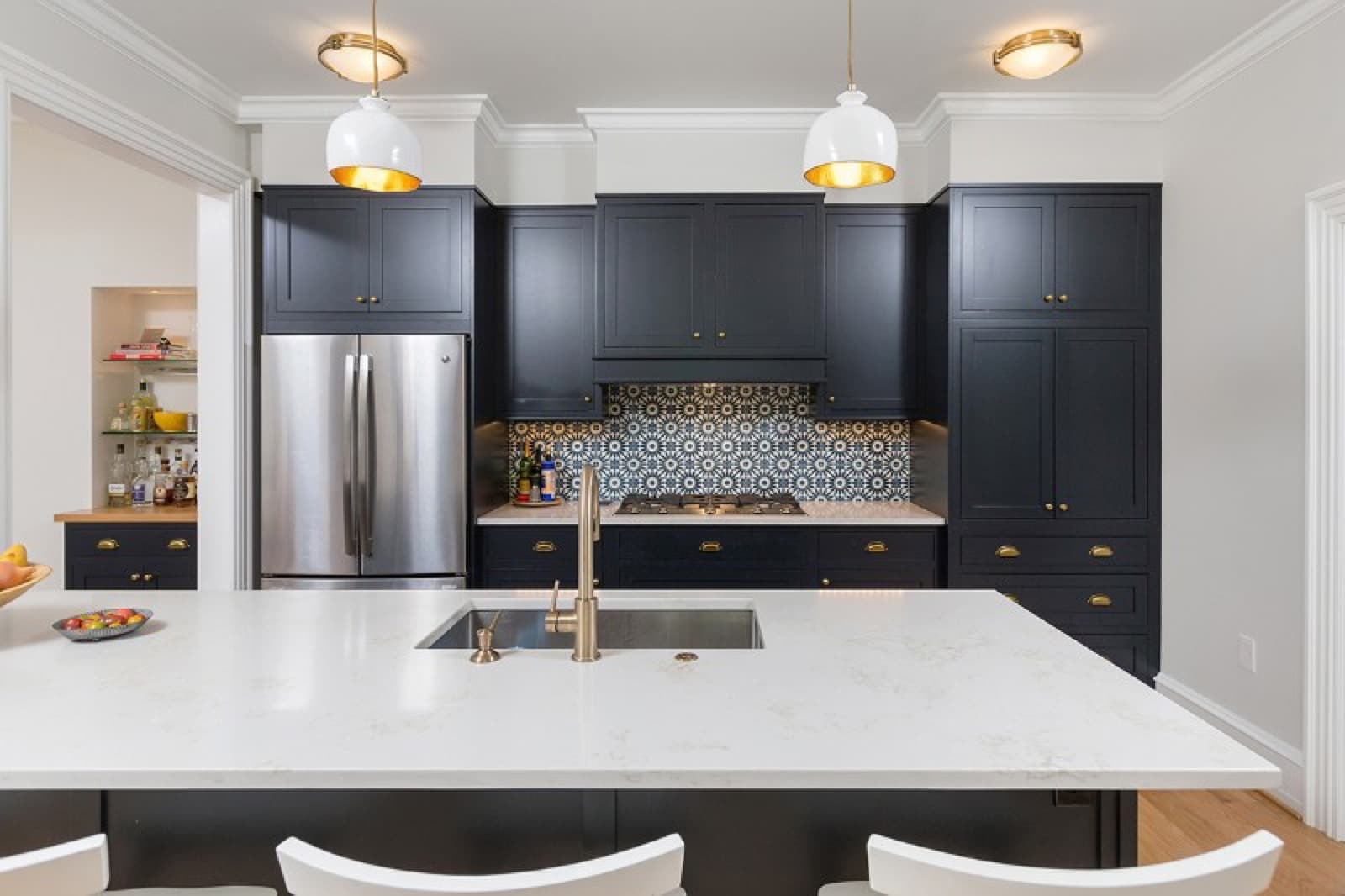 A fitted kitchen with dark cabinetry and a stone island